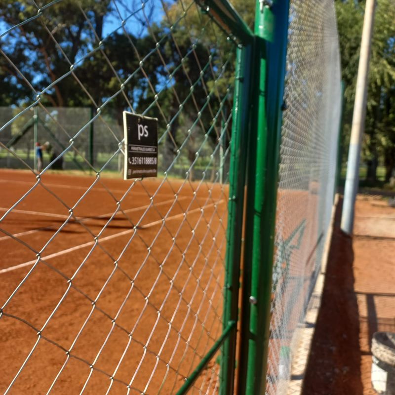 Cerco olímpico con cartel de Perimetrales Suarez en una cancha de tenis